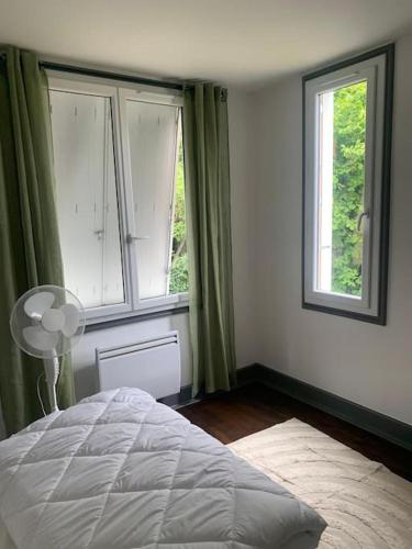 - une chambre avec deux grandes fenêtres et un lit dans l'établissement Appartement, à Gourdon