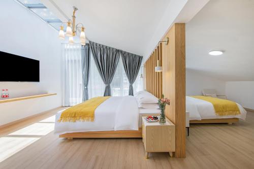 a bedroom with two beds and a flat screen tv at 安吉季意民宿 Jiyi Boutique Homestay, Anji, Huzhou in Anji
