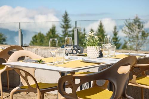 a table with chairs and wine glasses on a patio at Wellness Hotel Stoos in Stoos