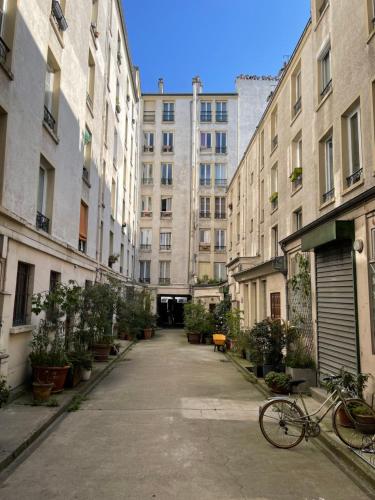 un vélo garé dans une ruelle entre les bâtiments dans l'établissement Appartement Paris 10 arr, à Paris