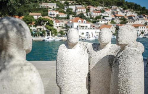 a group of stone statues looking out over a harbor at 2 Bedroom Stunning Home In Nerezisca in Nerežišća