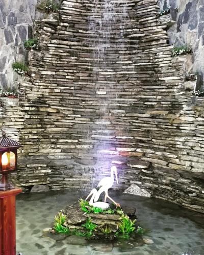 a statue of a bird in front of a waterfall at Museum Boutique Luxury GH in Sheki