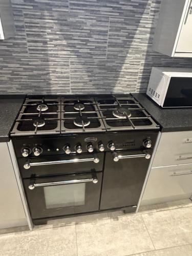 a stove top oven in a kitchen at Cosy rooms near Gatwick Airport in Ifield