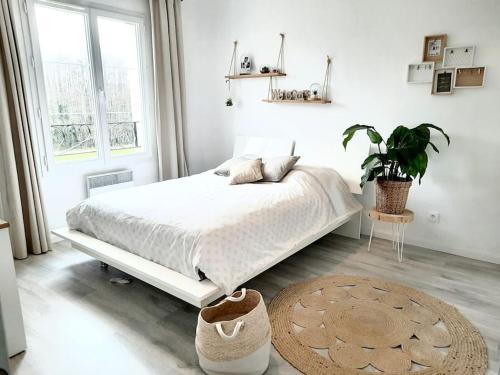 une chambre blanche avec un lit et une grande fenêtre dans l'établissement Maison de charme récente avec piscine hors sol, à Jouars-Pontchartrain