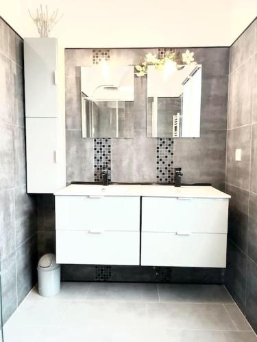 une salle de bain avec un lavabo blanc et un miroir dans l'établissement Maison de charme récente avec piscine hors sol, à Jouars-Pontchartrain