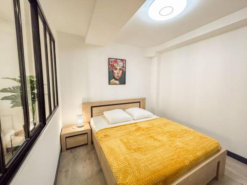une chambre avec un lit dans une pièce avec une fenêtre dans l'établissement T2 refait à neuf en plein centre-ville de Sanary, à Sanary-sur-Mer