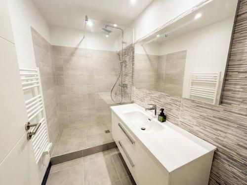 une salle de bain blanche avec un lavabo et une douche dans l'établissement T2 refait à neuf en plein centre-ville de Sanary, à Sanary-sur-Mer