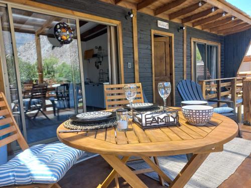 a wooden table with plates and glasses on a patio at Casa Refugio en Rivadavia in Vicuña