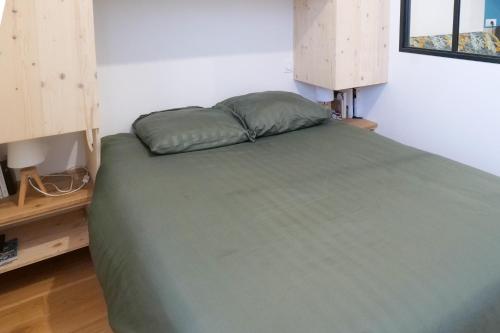 - une chambre dotée d'un lit avec un oreiller vert dans l'établissement Maison de pêcheur rénovée quartier La Chaume Les Sables - 4 personnes, à Les Sables-dʼOlonne