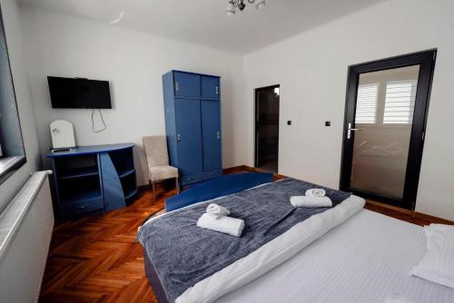 a bedroom with a large bed with two towels on it at Pensiunea RAVHOUSE in Vadu Izei