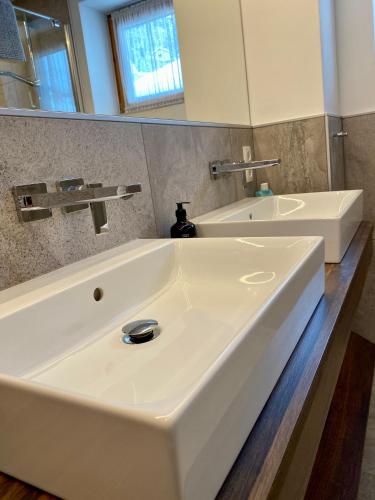 a bathroom with a white sink and a mirror at Valdafur Suites in Nauders