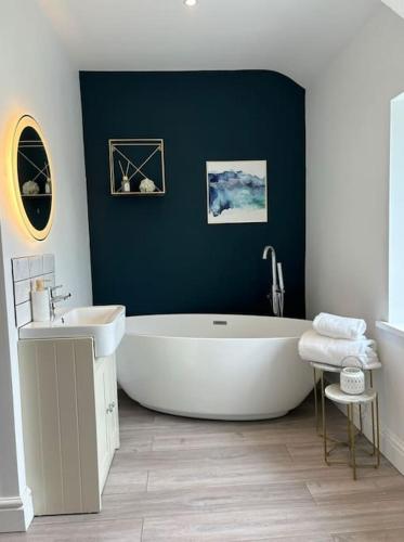 a bathroom with a white tub and a sink at House in the heart of Pembroke in Pembroke