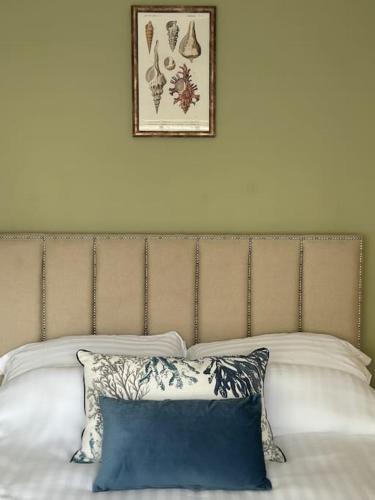 a headboard of a bed with two pillows and a picture at House in the heart of Pembroke in Pembroke