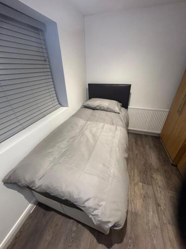 a bed in a room with a window at Cosy rooms near Gatwick Airport in Ifield