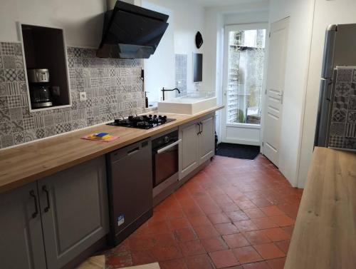 a kitchen with a sink and a stove top oven at Maison de maître in Bressuire