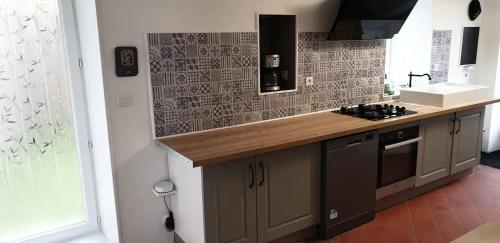 a kitchen with a counter with a sink and a stove at Maison de maître in Bressuire
