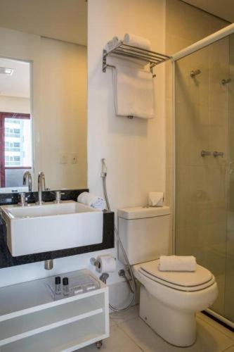 a bathroom with a toilet and a sink and a shower at Hotel Heritage in Sao Paulo