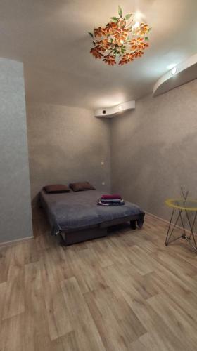 a bedroom with a bed and a chandelier at Однокомнатная квартира in Uralsk