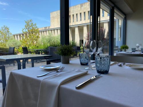 a table with a white table cloth and wine glasses at Hostatgeria de Poblet in Poblet