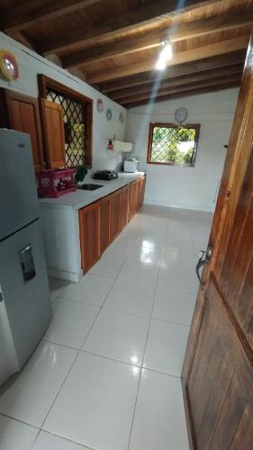 a kitchen with a white tile floor and a refrigerator at Finca los Martinez - Tamesis - Vereda San Isidro in Támesis