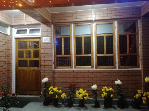 a house with a bunch of flowers in front of it at Namaste Nest in Mirik