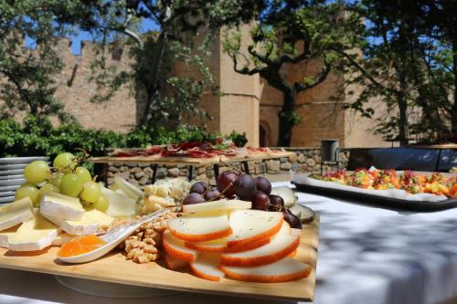 a table with several plates of cheese and fruit at Hostatgeria de Poblet in Poblet
