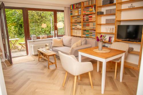 a living room with a couch and a table at Mitten im Grünen - Apartment mit Wohlfühlcharakter in Stadtrandlage in Eutin
