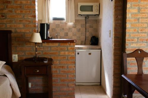 a kitchen with a small refrigerator and a microwave at Refugio de Luna -Cabañas & Suites- in Nono