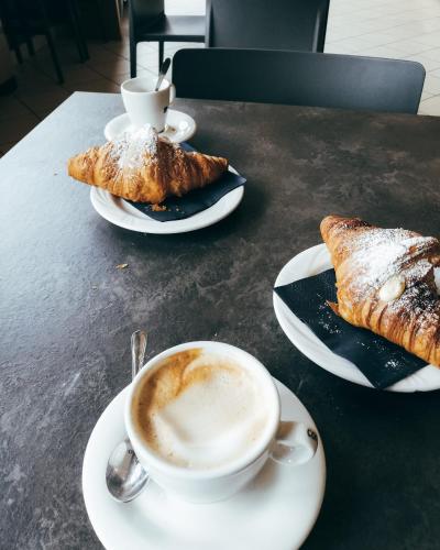 eine Tasse Kaffee und zwei Gebäckstücke auf einem Tisch in der Unterkunft La Casa di Stella in Termoli