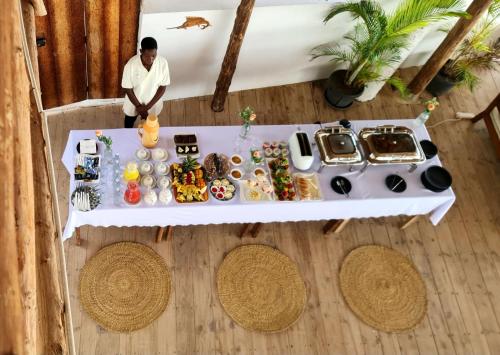an overhead view of a man standing next to a table with food at Mia Boutique Hotel in Michamvi