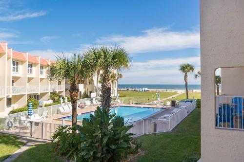 a view of the pool and beach from the balcony of a resort at Center of Saint Augustine Beach in St. Augustine