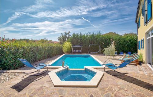 une piscine avec deux chaises et une table dans l'établissement Awesome Home In Naselje Muzini, à Tomišići