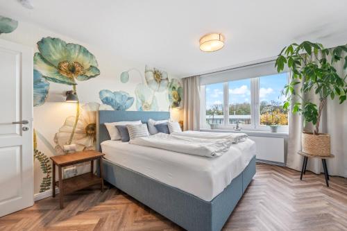 ein Schlafzimmer mit einem Bett und einem großen Fenster in der Unterkunft PEMATRA Haus Waterkant - FeWo Koje in Travemünde