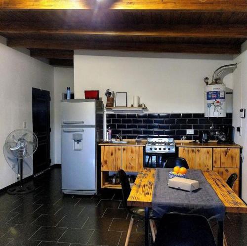 eine Küche mit einem Tisch und einem weißen Kühlschrank in der Unterkunft Aguarà del Sol-Aguarà Guazù in Valle Hermoso