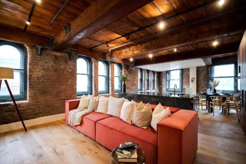 a living room with a red couch with white pillows at Organica by The Heim in Manchester