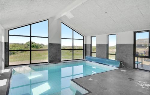 a large swimming pool with windows in a building at Nice Home In Blokhus With Wifi in Blokhus
