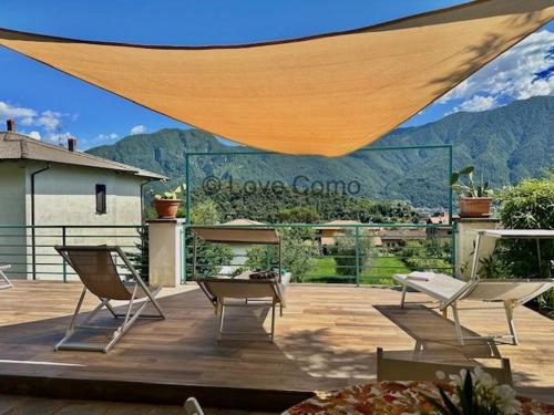 a patio with chairs and a table and a tent at Villa 3 Olivi - Lenno by LoveComo in Lenno