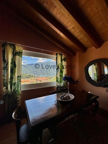 a dining room with a table and a window at Villa 3 Olivi - Lenno by LoveComo in Lenno