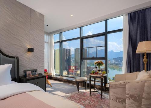 張家界市にあるVanbrugh Bay Hotel - Zhangjiajie Tianmen Mountainのベッドと大きな窓のある寝室