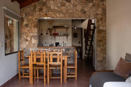 a kitchen and dining room with a table and chairs at Refugio de Luna -Cabañas & Suites- in Nono