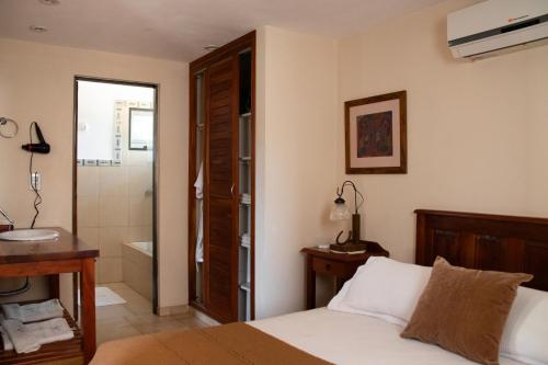 a bedroom with a bed and a bathroom with a sink at Refugio de Luna -Cabañas & Suites- in Nono