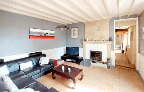 un salon avec un canapé et une cheminée dans l'établissement Nice Home In Argenton Leglise, à Argenton lʼÉglise