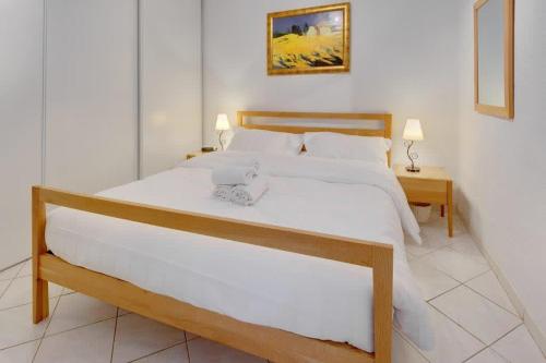 une chambre avec un grand lit blanc et une table dans l'établissement Rue St Gaetan location old town, à Nice