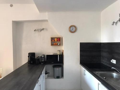 une cuisine avec un comptoir et une horloge murale dans l'établissement Rue St Gaetan location old town, à Nice