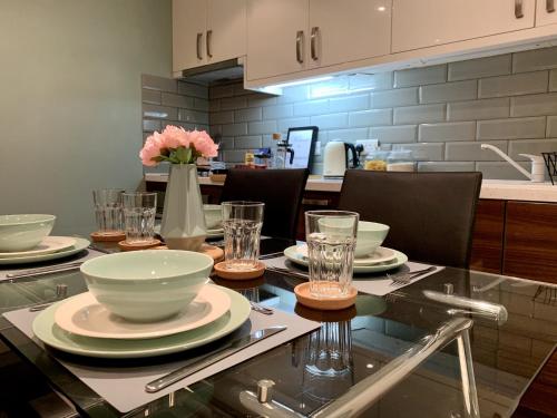 Una cocina con una mesa con platos y vasos encima. en Richmond House by Staytor Accommodation, en Exeter