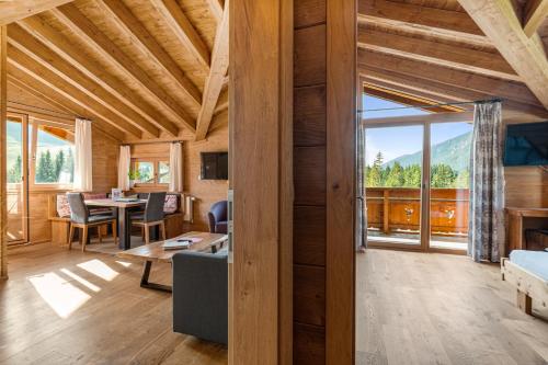 Una sala de estar con una mesa y una gran ventana. en Schickster Mountain Lodge, en Unterweidach