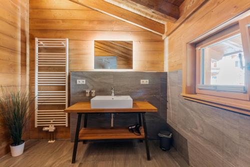 baño con lavabo en una pared de madera en Schickster Mountain Lodge, en Unterweidach