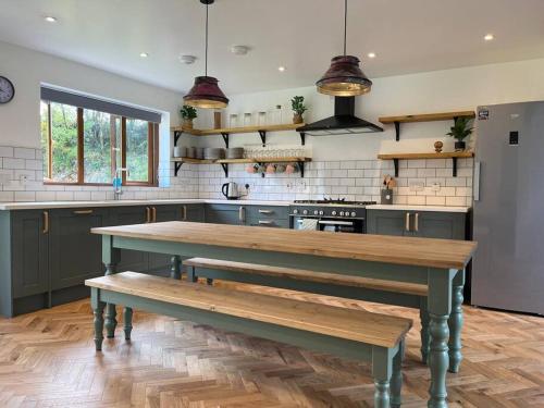 5-bed house near Rathmullan beach في راثمولان: مطبخ مع كرسي خشبي في الوسط