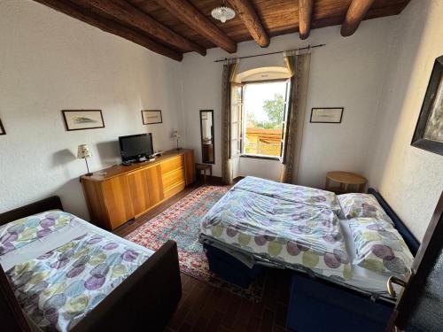 a bedroom with two beds and a television in it at Agriturismo Cervano in Toscolano Maderno