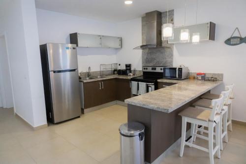 a kitchen with a stainless steel refrigerator and a counter at Ka' Romana Residences in El Soco